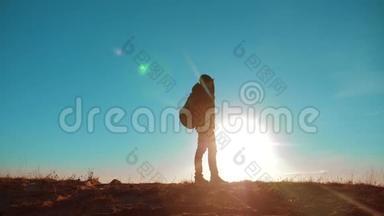 男子值得旅游与背包智能手机导航阳光<strong>站在山顶</strong>。 慢速视频